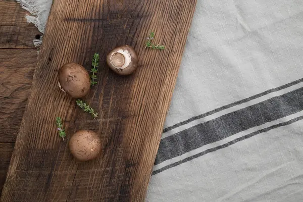 Portobello mantarı ve ahşap kesim tahtasındaki taze kekik..