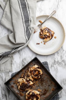 Küçük çikolatalı tarçınlı çörekler, düğümler ya da mermer kaplamalı yeni pişmiş kıvrımlar..