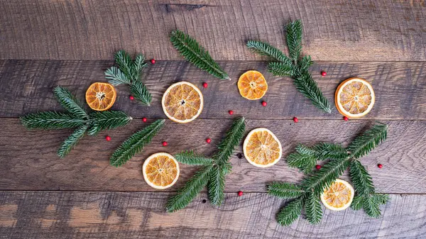 Çam ağacı dalları, kurutulmuş portakal dilimleri ve ağaç şeklinde kırmızı böğürtlenler..
