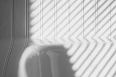 Dikey çizgili boncuk duvarda organik gri gölgeler ve beyaz ışık köşegenleri. Soyut mimari kapalı arkaplan, tek renk, siyah ve beyaz.