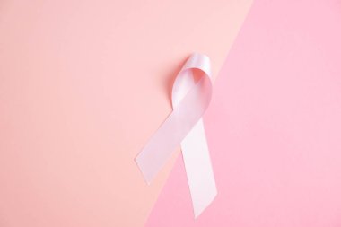 Göğüs kanseri. Pembe arka planın iki tonu üzerine pembe kurdele. Farkındalık kavramı