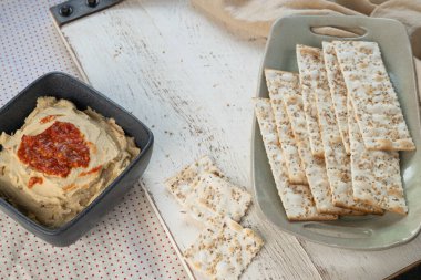 Kızarmış kırmızı biberli humus, otlu, tuzlu, yassı ekmek krakeri..
