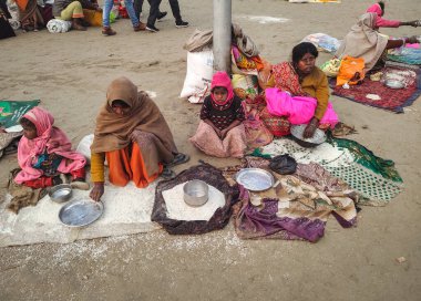 PRAYAGRAJ, UTTAR PRADESH, INDIA - 14 AĞUSTOS 2023: Hintli genç kadın çocuğuyla sokakta dilencilik yapıyor.