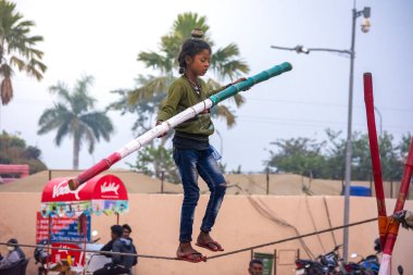 ORCHHA, MADHYA PRADESH, INDIA - 27 ARALIK 2021: Küçük köy kızı sirkte ip yürüyüşü yapıyor.