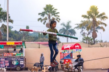 ORCHHA, MADHYA PRADESH, INDIA - 27 ARALIK 2021: Küçük köy kızı sirkte ip yürüyüşü yapıyor.