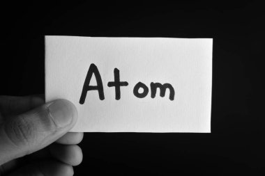 Elinde atomun yazılı olduğu bir kart tutuyordu.