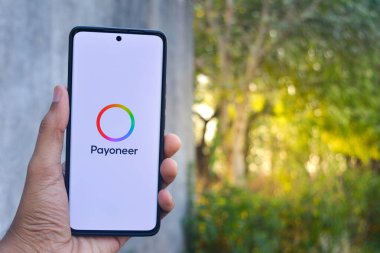 TIKAMGARH, MADHYA PRADESH, INDIA - 10 NİSAN 2025: Ekranda uygulama programcısı ile telefon tutan adam.