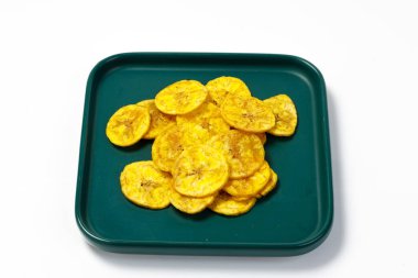 Kerala cipsi ya da muz cipsi, Kerala 'nın tarikat atıştırmalığı, yeşil seramik kare şeklinde bir tabakta düzenlenmiş, beyaz arkaplan ile izole edilmiş görüntü.