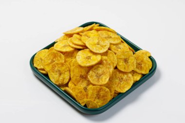 Kerala cipsi ya da muz cipsi, Kerala 'nın tarikat atıştırmalığı, yeşil seramik kare şeklinde bir tabakta düzenlenmiş, beyaz arkaplan ile izole edilmiş görüntü.