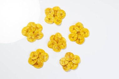 Kerala cipsi ya da muz cipsi, Kerala 'nın tarikat atıştırmalığı, Onam pookalam stilinde güzelce düzenlenmiş, beyaz arkaplan ile izole edilmiş görüntü.