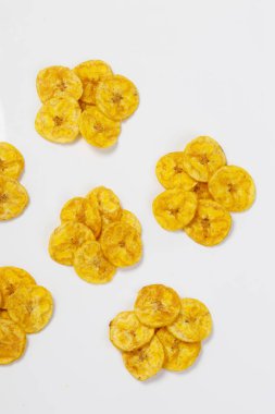 Kerala cipsi ya da muz cipsi, Kerala 'nın tarikat atıştırmalığı, Onam pookalam stilinde güzelce düzenlenmiş, beyaz arkaplan ile izole edilmiş görüntü.