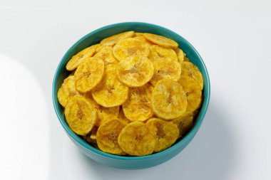 Kerala cipsi ya da muz cipsi, Kerala 'nın tarikat atıştırmalığı, hamur rengi seramik kasede düzenlenmiş, beyaz arkaplan ile izole edilmiş görüntü.