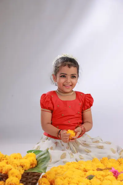 stock image A cute small girl child wearing  Kerala dress-golden colour long skirt and red blouse,onam festival theme, isolated white background.