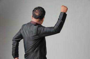 Geleneksel Hint kostümlü, sade arka planda, izole edilmiş, siyah kurta ve beyaz pijama giyen bir adam..