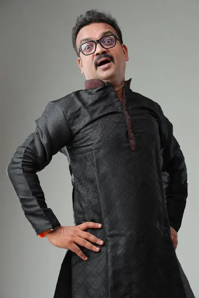 一个穿着印度传统服装的男人 背景朴素 与世隔绝 身穿黑色古塔和白色睡衣 免版税图库图片