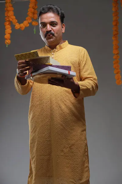 一个穿着印度传统服装的男人 背景朴素 与世隔绝 头戴黄色头巾 头戴白色睡衣 图库图片