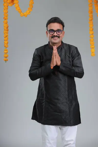 一个穿着印度传统服装的男人 背景朴素 与世隔绝 身穿黑色古塔和白色睡衣 免版税图库照片