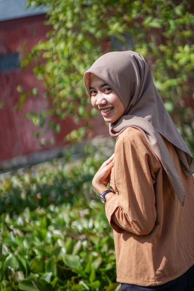 身穿现代头巾的美丽的亚洲穆斯林妇女的画像在绿色的花园中显得非常高兴 — 图库照片