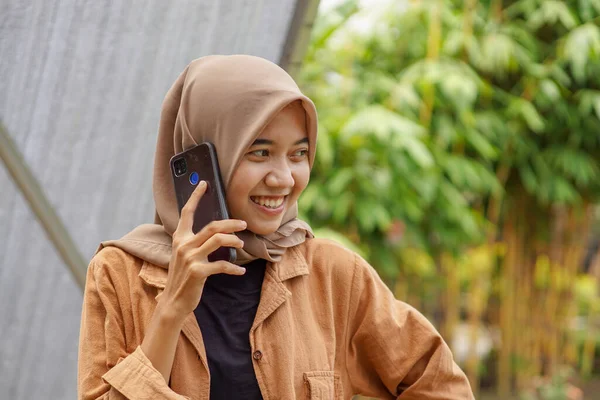 히잡을 아름다운 스마트폰을 사용하는 사람에게 전화를 있습니다 — 스톡 사진