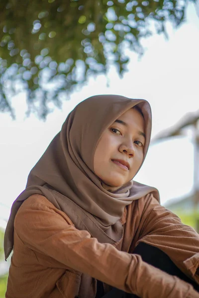 素敵な笑顔で公園に座っている現代のヒジャーブを着た美しいアジア系ムスリム女性の肖像画 — ストック写真