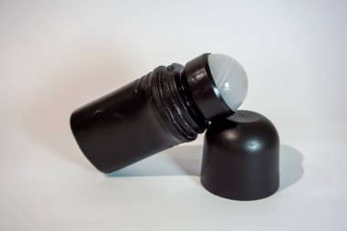 Beyaz arka planı ve gölgesi olan siyah şişe deodorantı.