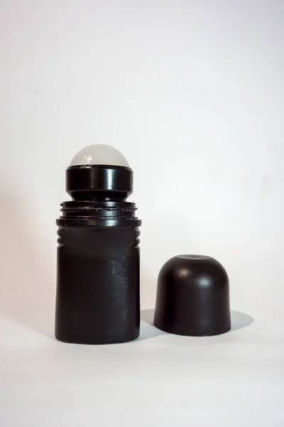 Beyaz arka planı ve gölgesi olan siyah şişe deodorantı.