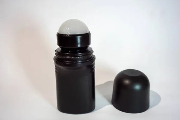 Beyaz arka planı ve gölgesi olan siyah şişe deodorantı.