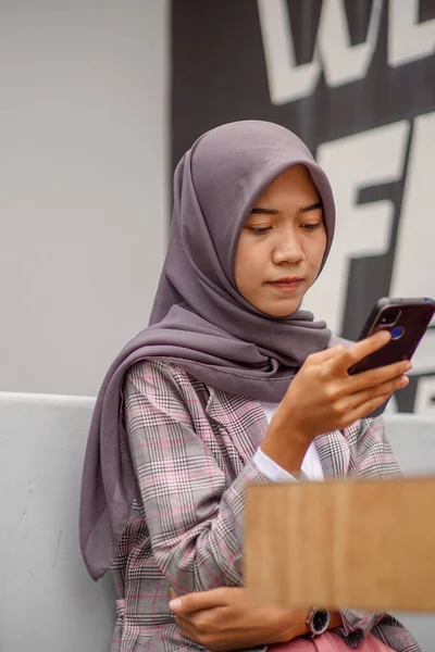 Hermosa Asiático Musulmán Mujer Usando Moderno Hijab Sentado Sonriendo Sosteniendo —  Fotos de Stock