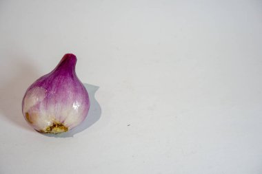 Soğanı soyutlar ve gri bir zeminde yatar.