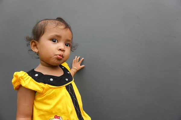 stock image cute asian little girl with chocolate covered mouth and gray background