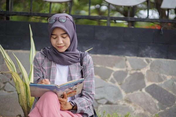 Красивая Азиатская Мусульманка Современном Хиджабе Сидит Пишет Своей Книге — стоковое фото