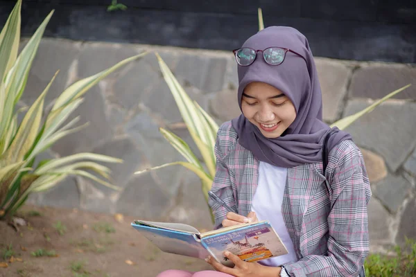 Красивая Азиатская Мусульманка Современном Хиджабе Сидит Пишет Своей Книге — стоковое фото