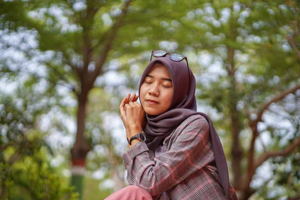 坐在公园里戴着现代头巾的美丽的亚裔穆斯林女子的侧影 — 图库照片