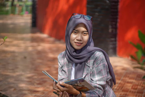美しいアジアの現代ヒジャーブ ムスリム女性学生が立って公園で日記をつけています — ストック写真