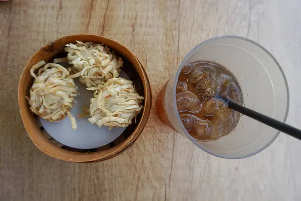 Udang ya da karides Rambutan, Erişteli karides katmanlı Çin mantısı bambu sepeti ve buzlu çay ile servis edilir.