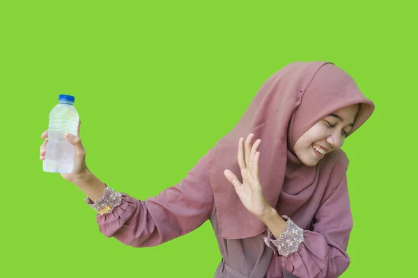 一位戴头巾的美丽的亚裔穆斯林女子拿着一瓶水 摆出绿色背景的拒绝姿态 亚洲妇女在拉面拒绝喝水期间禁食 — 图库照片