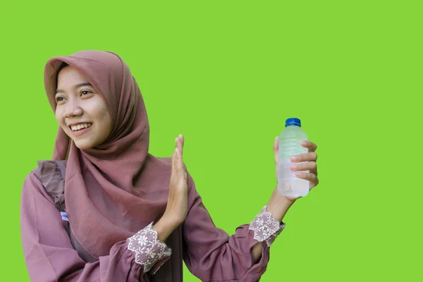 一位戴头巾的美丽的亚裔穆斯林女子拿着一瓶水 摆出绿色背景的拒绝姿态 亚洲妇女在拉面拒绝喝水期间禁食 — 图库照片