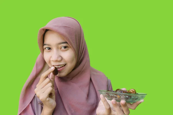 美丽的亚洲女人 带着绿色背景吃早餐的日期 穆斯林妇女头戴伊斯兰头巾和斋月观念的照片 — 图库照片