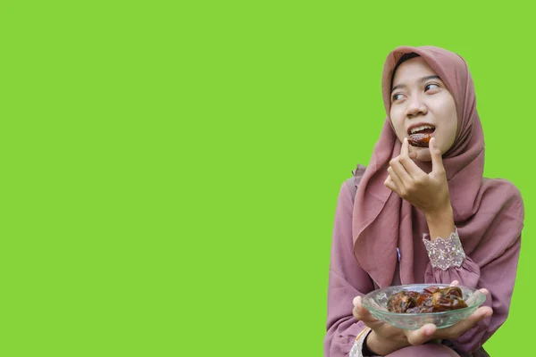 Красивая Женщина Хиджабе Ест Финики Разговения Зеленом Фоне Фото Мусульманских — стоковое фото