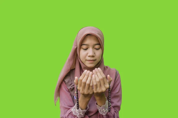 美しいアジア系イスラム教徒の女性ヒジャーブは手に祈りのビーズを持ち緑の背景を持つジェスチャーを祈る イスラム教とラマダーンの概念を持つヒジャーブを着たムスリム女性の写真 — ストック写真