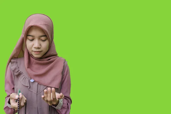 美しいアジア系イスラム教徒の女性ヒジャーブは手に祈りのビーズを持ち緑の背景を持つジェスチャーを祈る イスラム教とラマダーンの概念を持つヒジャーブを着たムスリム女性の写真 — ストック写真
