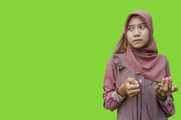 美しいアジア系イスラム教徒の女性ヒジャーブは緑色の背景で手に祈りのビーズを持っています イスラム教とラマダーンの概念を持つヒジャーブを着たムスリム女性の写真 — ストック写真