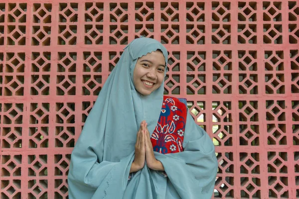ヒジャーブの礼服を着た美しいアジア系イスラム教徒の女性がイスラム教の装飾の壁の背景で挨拶の手をポーズ ラマダーンとイード フィトルのコンセプトを持つムスリム女性の写真 — ストック写真