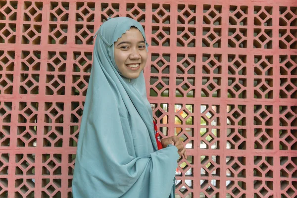 イスラム教の装飾の壁の背景を持つスカーフの祈りの服を着て美しいアジアのイスラム教徒の女性 ムケナという礼服です ラマダーンとイード フィトルのコンセプトを持つムスリム女性の写真 — ストック写真