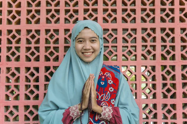 ヒジャーブの礼服を着た美しいアジア系イスラム教徒の女性やイスラム教の装飾の壁の背景を持つ祈りのビーズを保持します ラマダーンとイード フィトルのコンセプトを持つムスリム女性の写真 — ストック写真