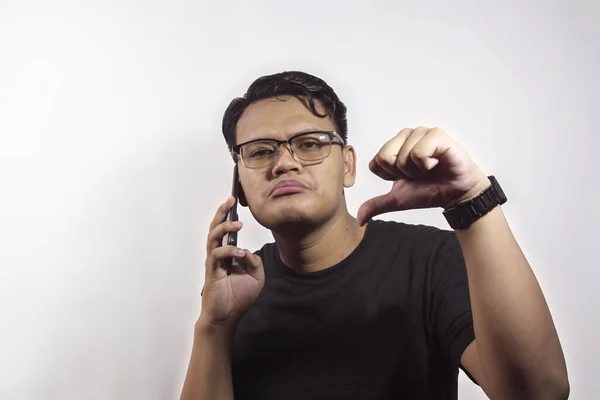 年轻英俊的亚洲男人穿着黑色T恤 打电话给使用智能手机的人 脸上带着否定的表情 无声无息地拒绝了 — 图库照片