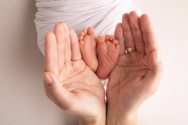 Bacaklar, ayak parmakları, ayaklar ve yeni doğmuş bir bebeğin topukları. Anne babanın elleriyle, baba, anne çocuğun bacaklarını nazikçe tutuyor. Makro fotoğrafçılık, yakın çekim. Siyah beyaz fotoğraf. Yüksek kalite fotoğraf.