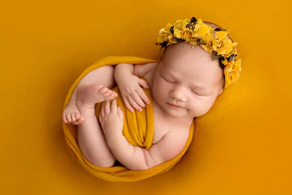 オレンジの巻きで寝ている新生児の女の子のトップビュー 彼女の頭の上にオレンジの包帯で オレンジの背景に 小さな新生児の美しい肖像画7日 1週間前 — ストック写真