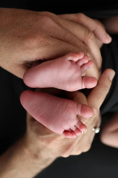 Una Madre Sostiene Los Pies Niño Recién Nacido Con Una — Foto de Stock