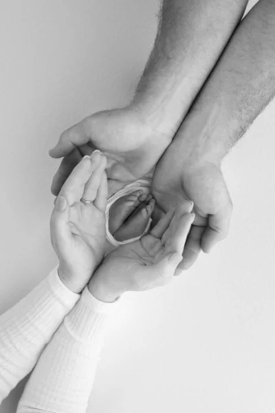 両親の手の中に子供の足 小さな新生児の足を閉じる 赤ん坊の足だ ママと子供だ 幸せな家族の概念 黒と白 母の写真 — ストック写真